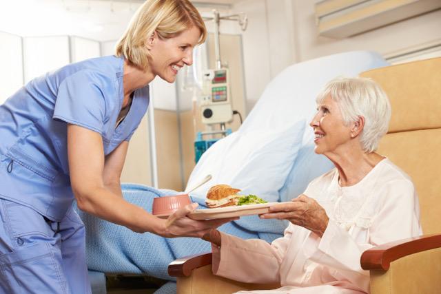 nurse serving meal to patient